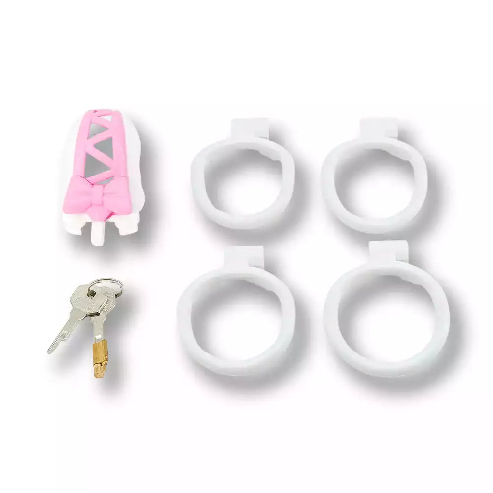 Kit complet incluant la cage de chasteté Sissy Coquette, son jeu de clés avec barillet et 4 anneaux ergonomiques blancs interchangeables pour un ajustement sur mesure sur sissyshop.
