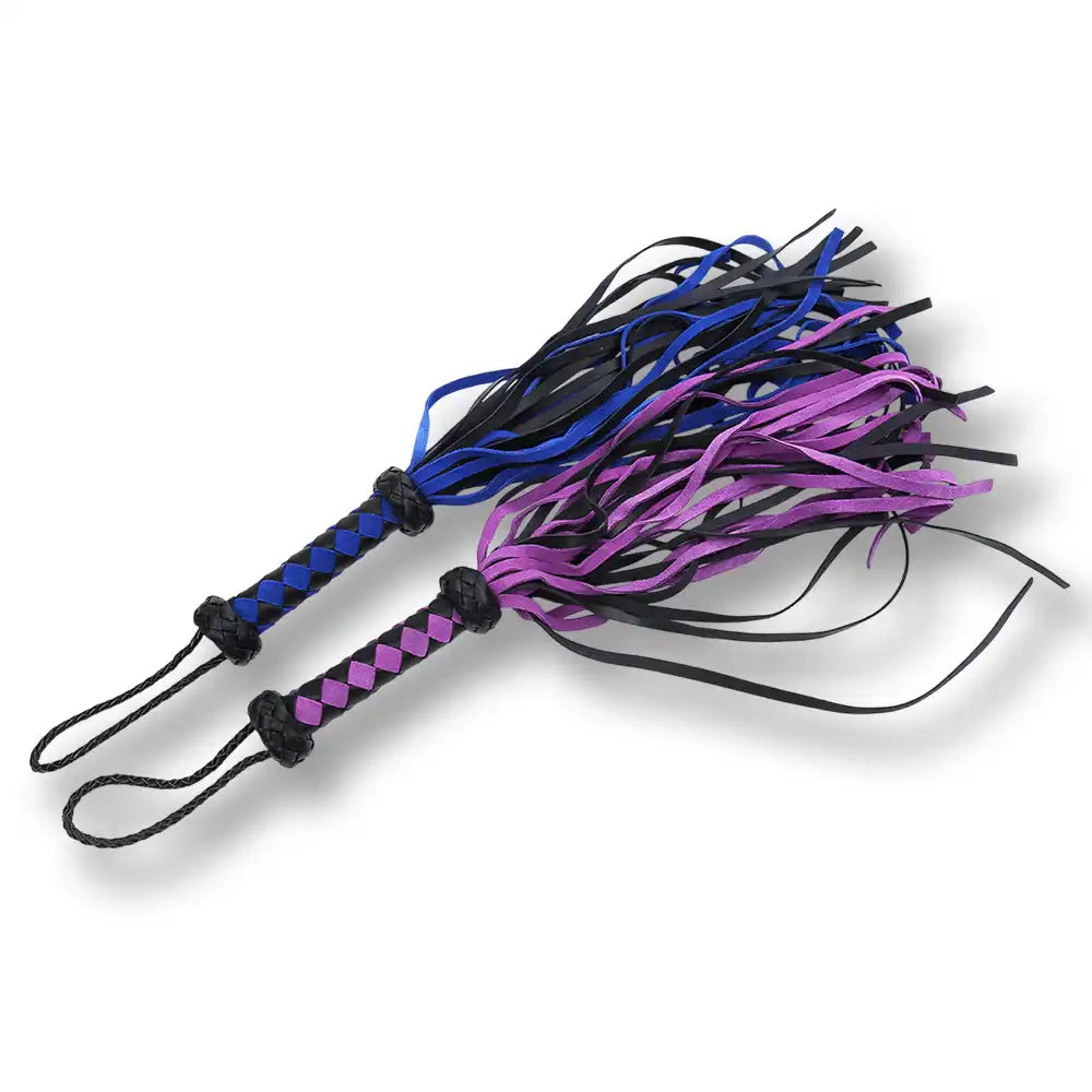 Présentation de floggers bicolores en cuir souple (violet/noir et bleu/noir) pour accessoires de bondage et domination.