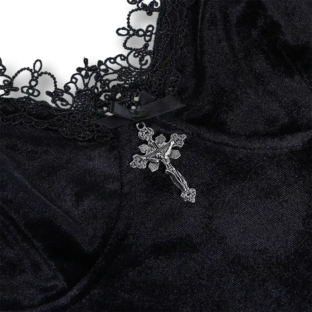 Gros plan sur le décolleté bordé de dentelle noire et le petit pendentif en croix argentée de la robe gothique.