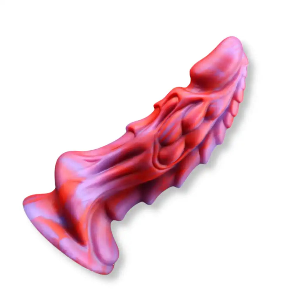 Dragon dildo crépuscule ardent en silicone bicolore rouge et violet, incliné pour montrer les détails des reliefs et la base ventouse, parfait pour la sissification.