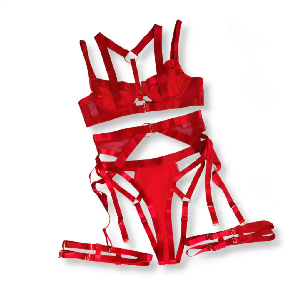 Ensemble de lingerie rouge à sangles présenté à plat comprenant soutien-gorge, string et jarretelles, accessoire de séduction pour adultes.