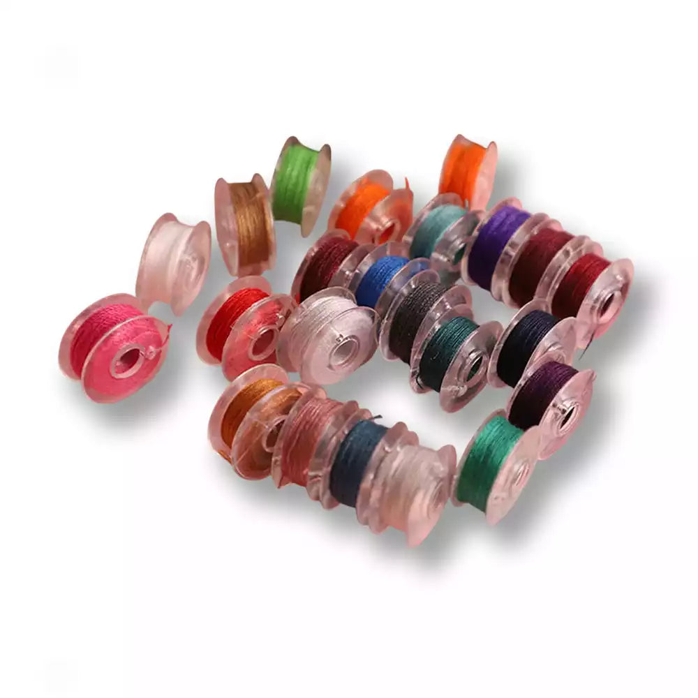 Assortiment de petites canettes de fil à coudre transparentes multicolores, idéales pour machine à coudre ou petites retouches à la main sur la boutique sissyshop.