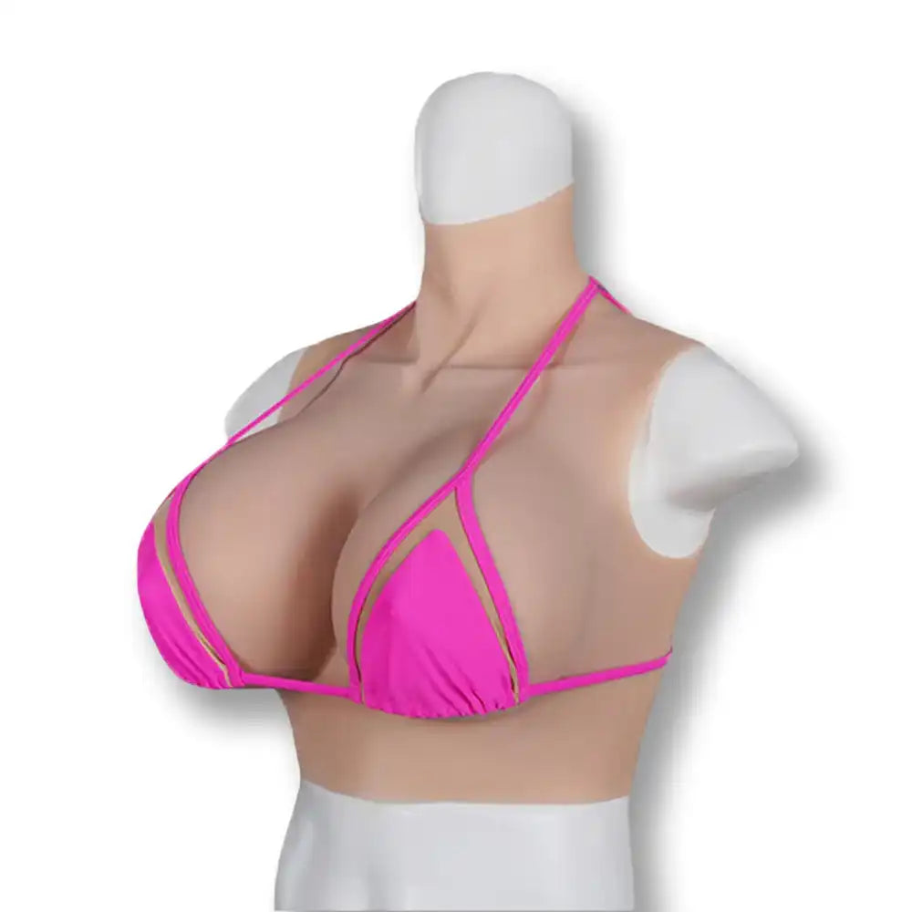 Vue de trois-quarts de la prothèse en silicone avec son bikini rose, illustrant l'intégration parfaite de ces faux seins pour homme conçus pour la féminisation sur la boutique sissyshop.