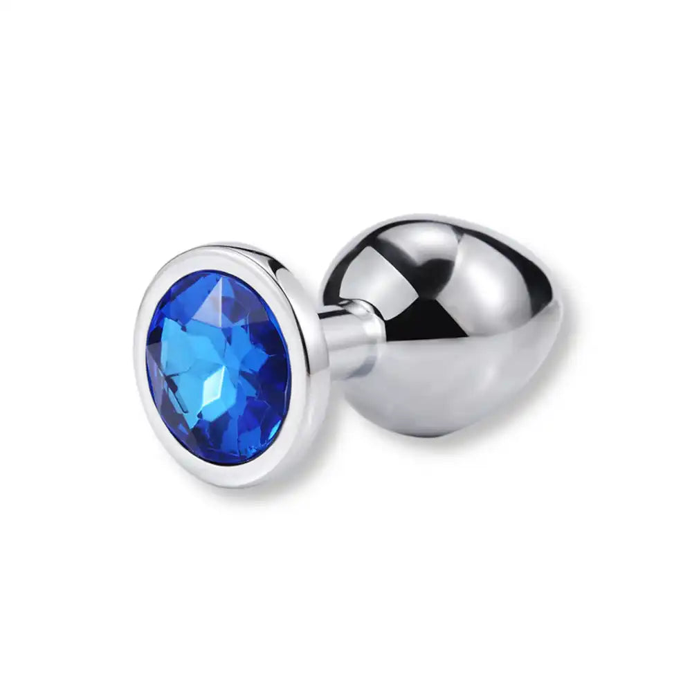 Plug anal en métal argenté serti d'un strass bleu saphir sur sa base plate, un plug anal bijoux parfait pour les adeptes de la culture sissy.