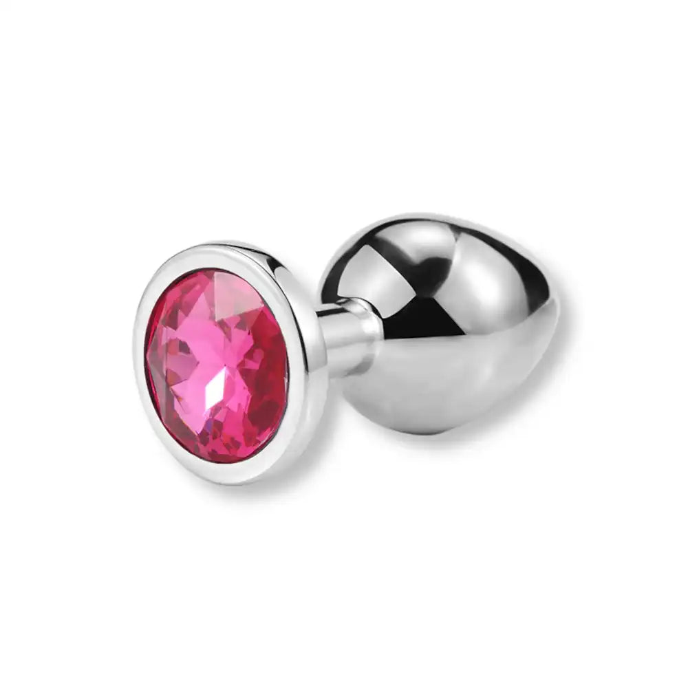 Plug anal en métal argenté avec un strass rose brillant sur sa base, un plug anal pour homme et sissy disponible sur la boutique sissyshop.