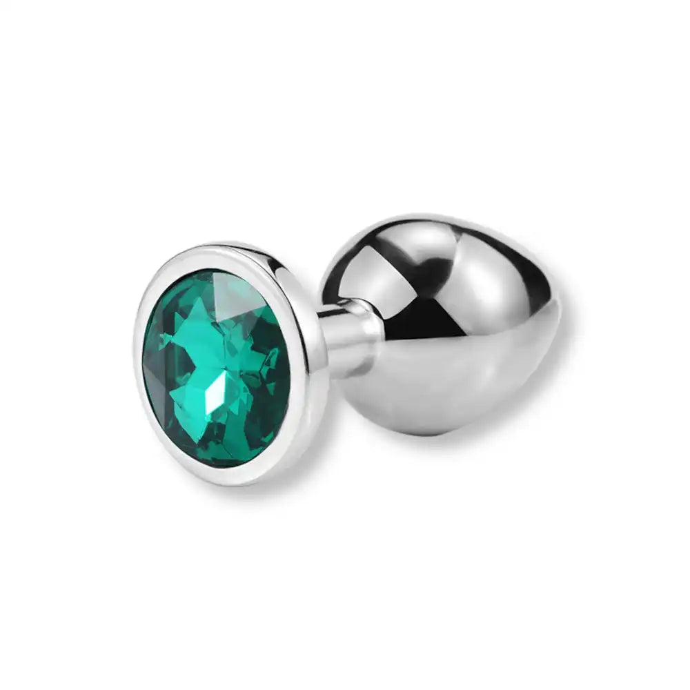 Plug anal en métal argenté orné d'un strass vert émeraude, un bijou intime idéal pour accompagner votre parcours de sissification sur sissyshop.