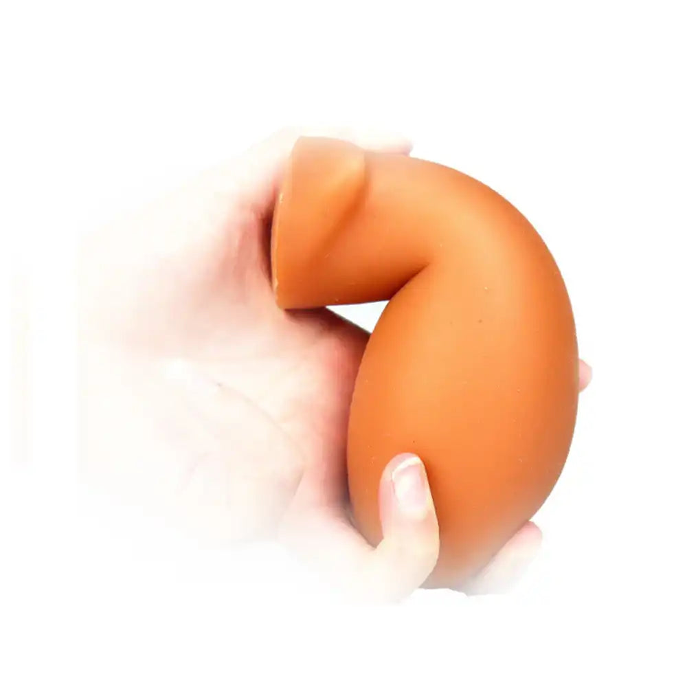Démonstration de la flexibilité du plug anal Dragon Egg en silicone orange, disponible sur Le Sissyshop.