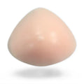Vue de face d'une prothèse en silicone de forme triangulaire avec téton intégré, l'accessoire faux seins silicone indispensable pour une sissification réussie sur sissyshop.