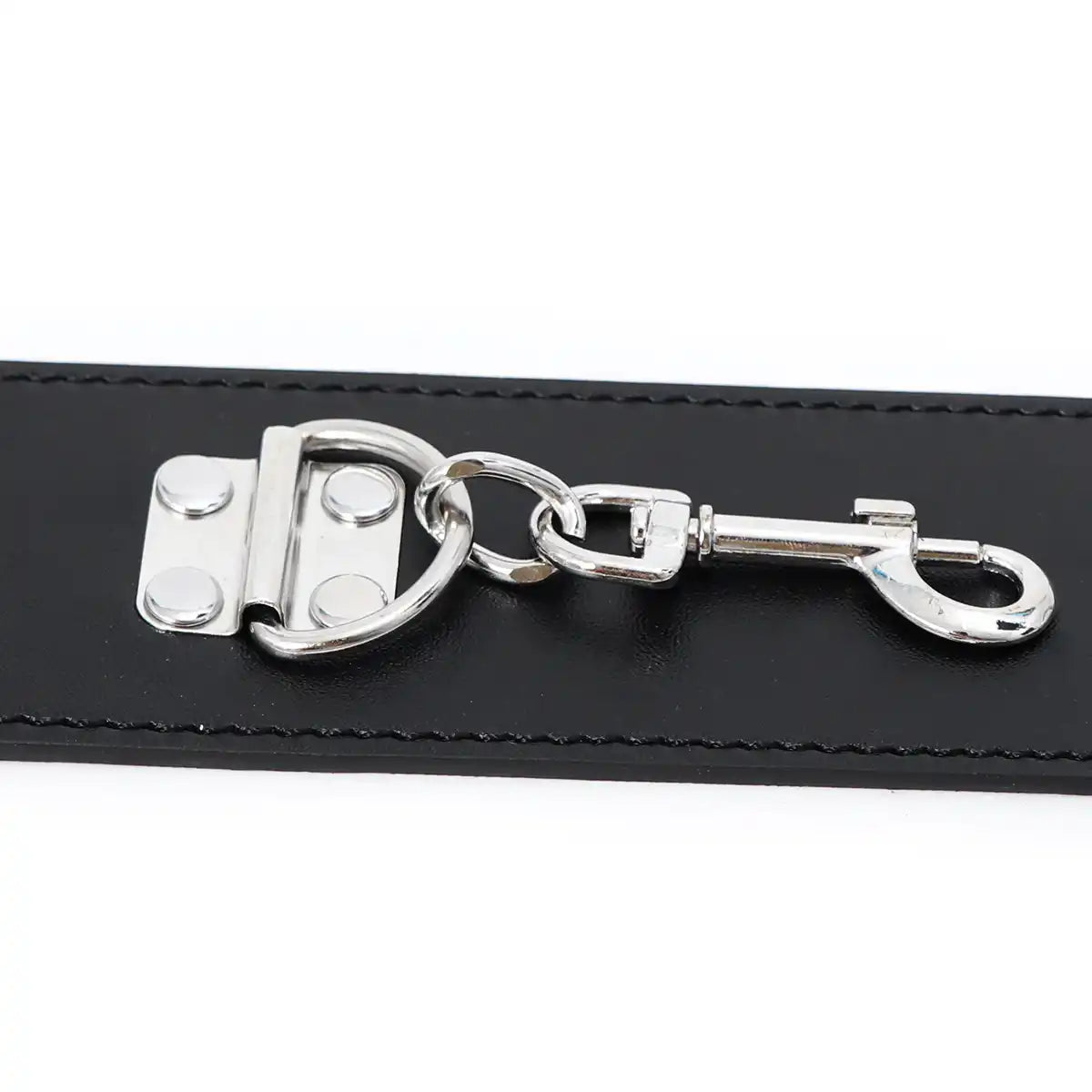 Détail de l'anneau en D et du mousqueton en acier sur sangle noire pour accessoires de selfbondage et de domination.