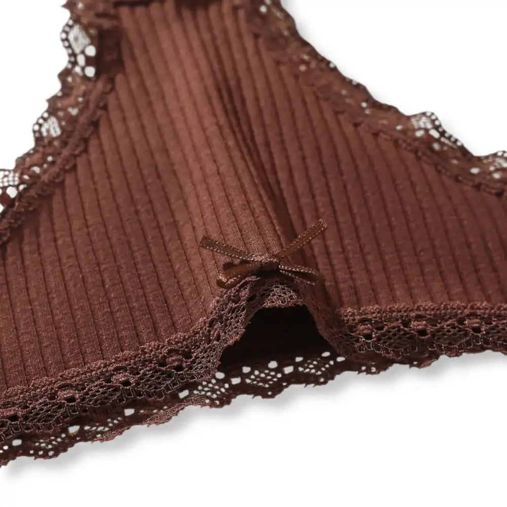 Gros plan sur le délicat petit nœud en satin et les bordures en dentelle sur l'avant de cette culotte coton, apportant une touche féminine parfaite pour vos moments de sissification sissyshop.